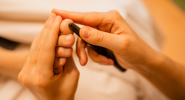 Thailändische Fußmassage mit Massagestäbchen